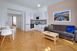 a living room with a couch and a table at Downtown Suites Kodanska in Prague