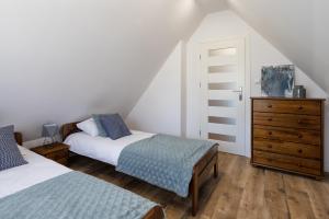 a attic bedroom with two beds and a dresser at Apartament na Szczycie in Bukowina Tatrzańska