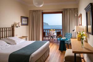 a hotel room with a bed and a view of the ocean at Parador de El Hierro in Las Casas