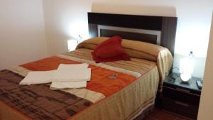 1 dormitorio con cama con almohada roja y sábanas rojas en Pension Gran Plaza en Sevilla