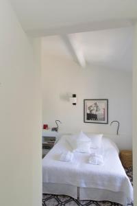 a white bedroom with a bed with white sheets at Villa Vagabonde in Gordes