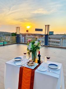 una mesa con copas de vino y un jarrón de flores en Marlin Hotel en Surat Thani