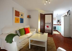 een woonkamer met een witte bank en een tafel bij LA CASA DE LA PLAYA 1 in Tarifa