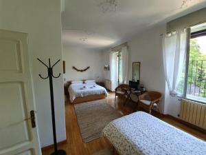 a bedroom with two beds and a desk and a window at B&B I Ghiri in Bergamo