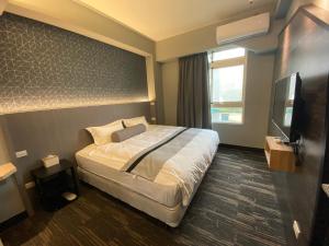 een hotelkamer met een bed en een flatscreen-tv bij 雅舍 Arthur Hostel in Jinning