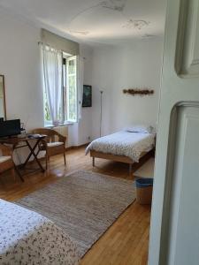 a bedroom with two beds and a table with a desk at B&B I Ghiri in Bergamo