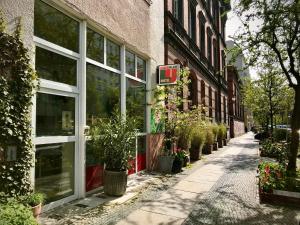 an empty street in front of a building with potted plants at Lekkerurlaub in Berlin