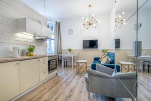 eine Küche und ein Wohnzimmer mit einem Tisch in der Unterkunft Apartamenty Katrin Home in Toruń