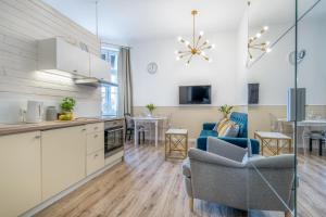 a kitchen and a living room with a table at Apartamenty Katrin Home in Toruń