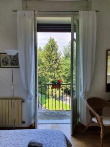 1 dormitorio con puerta que da a un balcón en B&B I Ghiri en Bérgamo