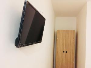 a flat screen tv hanging on a wall next to a wooden cabinet at EUROPEAN HOUSE in Constanţa