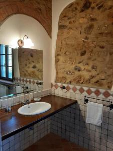 uma casa de banho com um lavatório e uma parede de pedra em Agriturismo Lupo Vecchio em Grosseto