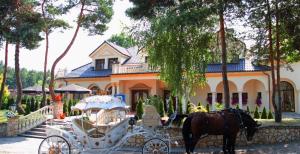 a horse drawn carriage in front of a house at Hotel Korona in Rybnik