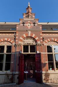 a brick building with a clock on the front of it at Boutiquehotel Staats in Haarlem