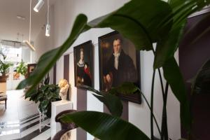a hallway with paintings of a man and a woman at Boutiquehotel Staats in Haarlem