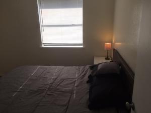 a bedroom with a bed with a window and a lamp at Fully furnished two bedroom apartment in Lawton