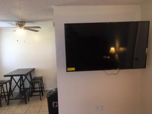 TV de pantalla plana colgada en una pared con mesa en Fully furnished two bedroom apartment, en Lawton