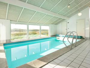 Grønhøjにある10 person holiday home in L kkenの大きな窓付きの客室内のスイミングプールを利用できます。