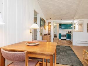 cocina y comedor con mesa de madera y sillas en 8 person holiday home in Hj rring en Lønstrup