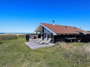 una casa con sedie e un tavolo da picnic di fronte ad essa di 6 person holiday home in Hj rring a Lønstrup