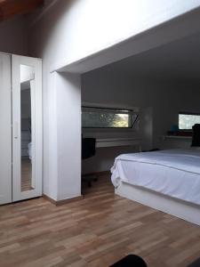 - une chambre avec un lit blanc et une fenêtre dans l'établissement BRIGHT MEZZANINE FLAT WITH GARDEN, à Athènes