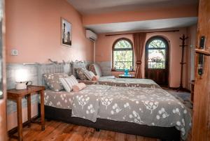 2 Betten in einem Schlafzimmer mit rosa Wänden in der Unterkunft My Guest Rooms in Plowdiw
