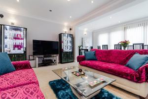 un soggiorno con divano rosso e TV di Brooklyn House a Barnet