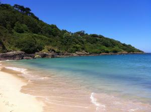 einen Strand mit klarem blauen Wasser und einem Berg in der Unterkunft Beachside Apartment in Carbis Bay