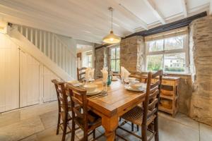 a dining room with a wooden table and chairs at Rose in Vale Cottage in Perranzabuloe