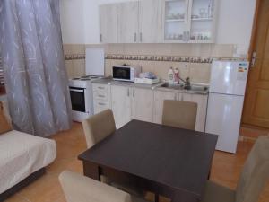 a kitchen with a table and a white refrigerator at Apartments Jovanović in Perast