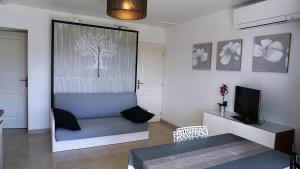 a living room with a tree on the window at Le Mas des Oliviers in Gréoux-les-Bains +43 photos