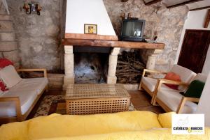 sala de estar con chimenea y TV. en Casa Rural Calabaza & Nueces, en Cazorla