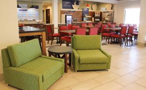 a restaurant with chairs and tables and a bar at Holiday Inn Express Osage Beach - Lake of the Ozarks, an IHG Hotel in Osage Beach