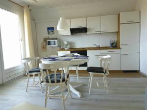 a kitchen with a table and chairs in a room at Birkenhof Neuharlingersiel in Neuharlingersiel