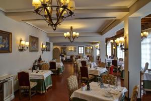 un ristorante con tavoli, sedie e lampadario a braccio di Parador de Calahorra a Calahorra