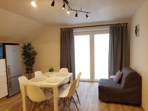 eine Küche und ein Wohnzimmer mit Tisch und Stühlen in der Unterkunft Willa Sandra in Szczawnica