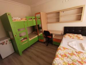 een slaapkamer met groene stapelbedden en een bureau bij Çanakkale Kampüs Pansiyon in Canakkale