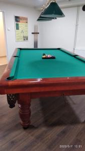 una mesa de billar en una habitación con un paño verde en Hotel Arena en Rybnik