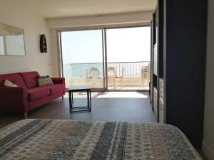 a bedroom with a bed and a couch and a balcony at Cap sur l'Océan pour 3 personnes in La Baule