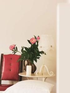 a table with a vase of flowers and a lamp at Casa File de Poveste in Târgu Jiu