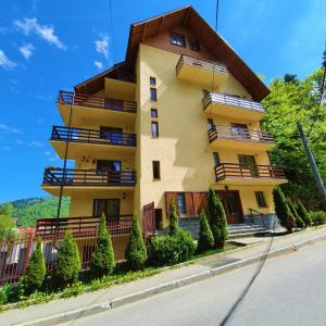 a yellow building with balconies on the side of a street at Forest Apartments in Sinaia