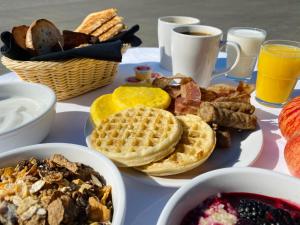 a table with a plate of waffles and other breakfast foods at Adam's Airport Inn in Ottawa +18 photos