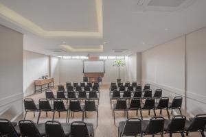 a conference room with chairs and a screen at Intercity Curitiba Centro Cívico in Curitiba