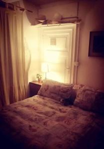 a bedroom with a bed with a window and a lamp at Monte Termine Country House in Rioveggio