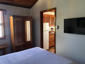 a bedroom with a bed and a television on a wall at Colinda Cabanas in Caye Caulker