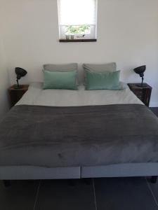 una camera da letto con un grande letto con cuscini verdi di Gastenverblijf De Viking a Zuid-Beijerland