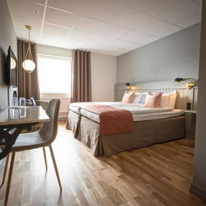 1 dormitorio con cama, escritorio, mesa y silla en Lundsbrunn Resort & Spa en Lundsbrunn