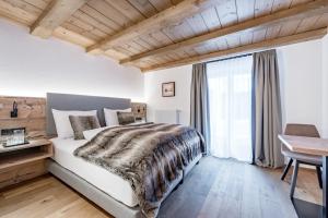 レッヒにあるBühlhof Appartementsの木製の天井が特徴のベッドルーム1室(大型ベッド1台付)