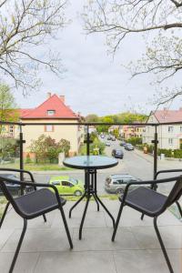 シフィノウイシチェにあるApartamenty Świnoujście - Flotyllaの通りの景色を望むバルコニー(テーブル、椅子付)