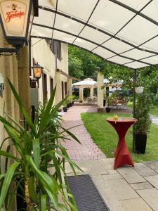 a patio with a red table under awning at Parkhotel Zirndorf in Zirndorf